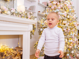 Boy with Down syndrome at the Christmas tree, genetic anomaly, Christmas photography, disabled...