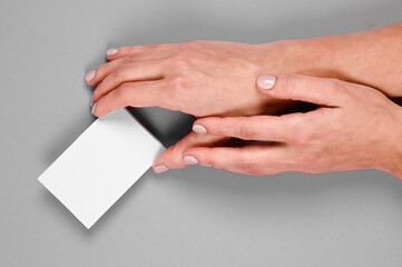 Obraz premium Fashionable ultimate gray pantone color of the year 2021. Female hands with empty card. Color trend concept