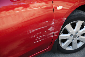 Modern red car with scratch outdoors, closeup