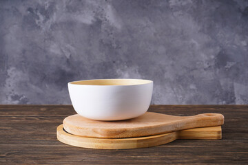 Cutting boards and a bowl on a wooden background, place for text.