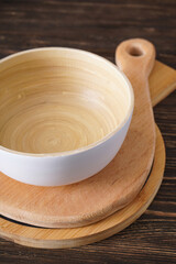 Wooden cutting boards and a bowl on a wooden background, flat lay.