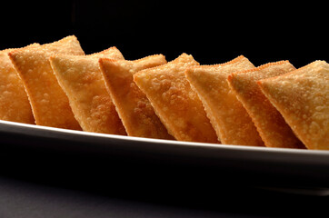 fried pasties served on table on dark background
