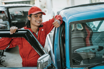 portrait of a young man working as an auto mechanic in a garage