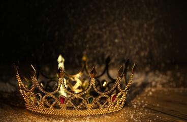 Beautiful golden crown with gems on wooden table. Fantasy item