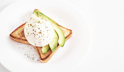 Toast with poached eggs and avocado. Healthy breakfast and food. Cozy morning. Nutrition for pregnant. Diet for women. Breakfast in hotel room or bed. Scrambled eggs sandwich.
