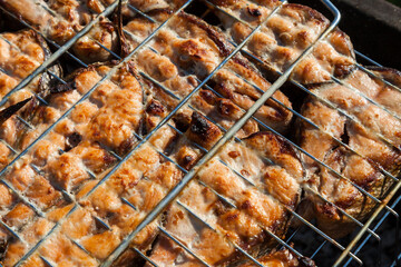Top view of the browned steaks of red coho salmon fried on charcoal in a barbecue on a summer day in the country. Cooking a wholesome outdoor grill dinner.