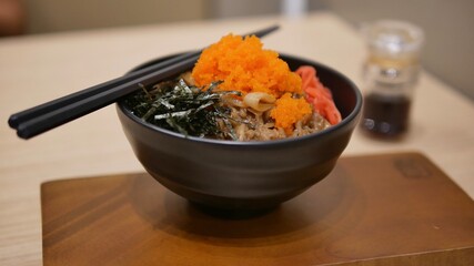 Bowl of rice topped with pork, seaweed and tobiko