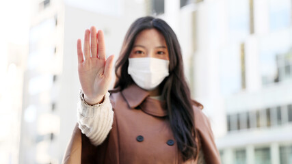 Covid-19 concept / Asian woman wearing face mask showing gesture Stop Infection