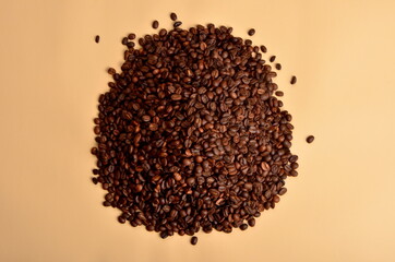 Round coffee beans stack on a beige background, copy space