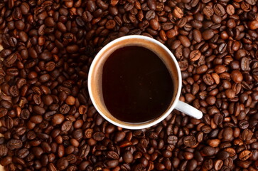 Coffee beans background with hot coffee mug