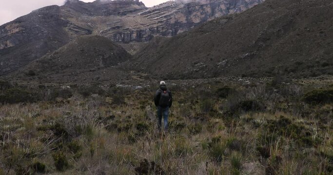Man hiking in mountain landscape with paramo vegetation in Boyaca, Colombia, Sierra Nevada del Cocuy range