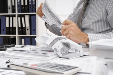 business problem concept - disappointed businessman has trouble and tears up reports