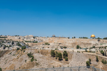 Fototapeta na wymiar Dome of Al-Aqsa Mosque and golden dome of the Rock, built on top of the Temple Mount, known as Haram esh-Sharif in Islam and wall of old city of Jerusalem, Israel. View from Mount of Olives.