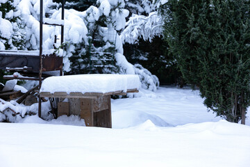 Winter fairy tale. Snow-covered courtyard, barbecue with a wooden table, trees covered with snow