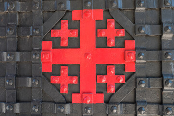 The Jerusalem cross  on the black steel door of  Garden of Gethsemane, next to the Church of All Nations, or Church or Basilica of the Agony. It is  the symbol of the Custody