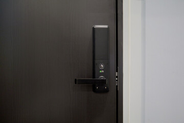 Digital door lock security systems for access protection of hotel, apartment door. Electronic door handle on black wood panel. Selective focus