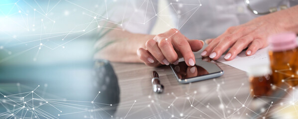 Female doctor using her mobile phone; panoramic banner