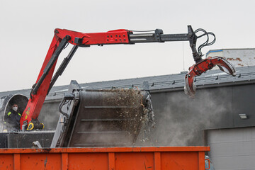 Scrap yard. Metal and waste shredding system. Excavator loading junk