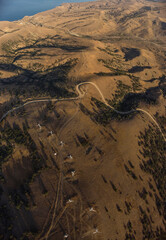 Aerial drone panorama shot of mountain area, windmills, the long and winding road through the mountains. Southern region, sands, desert 