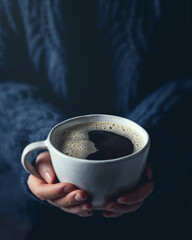 Woman hands holding a cup of hot coffee