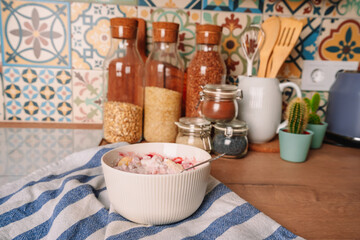 Prepare Breakfast in the modern kitchen with oven-style tiles. Cottage cheese with jam. Kitchen utensils and jars of cereals