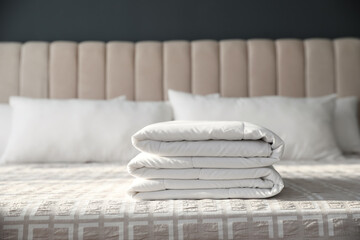 Fototapeta na wymiar Folded clean blanket on bed in room