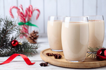 Delicious Christmas cocktail with liqueur on white wooden table. Space for text