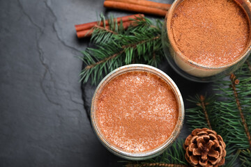 Delicious Christmas cocktail with liqueur on black table, flat lay