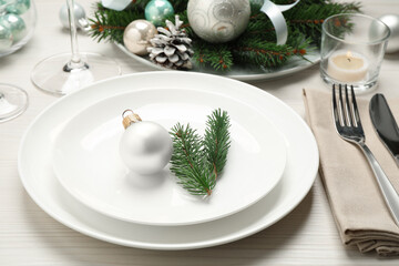 Festive table setting with beautiful dishware and Christmas decor on white wooden background