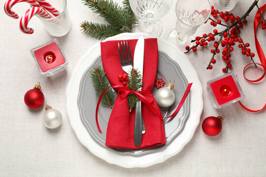 Festive table setting with beautiful dishware and Christmas decor on white background, flat lay