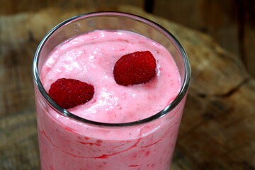 Raspberry smoothie on wooden background