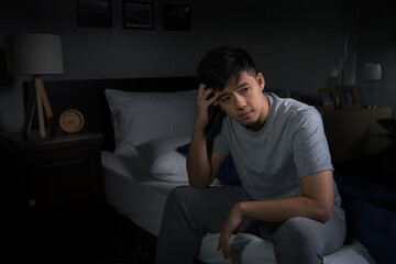 Fototapeta na wymiar Depressed young man suffering from insomnia sitting in bed..