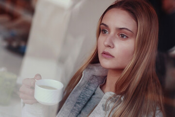 blond long hair girl close up portrait through the cafe window