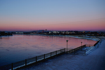 Fototapeta na wymiar Embankment of the Angara river at sunset. Winter cityscape