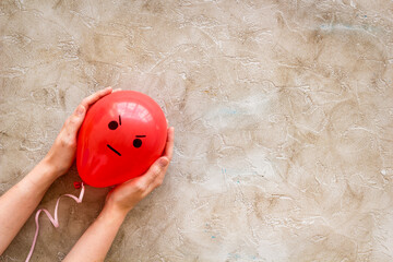 Anger emotion face on balloon - madness mood background. Top view, copy space