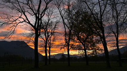 Suggestivo tramonto sul lago in autunno, con nuvole colorate di rosa, rosso e arancione. Immagine molto bella.  © fotonaturali