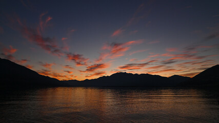 Suggestivo tramonto sul lago in autunno, con nuvole colorate di rosa, rosso e arancione. Immagine molto bella.  © fotonaturali