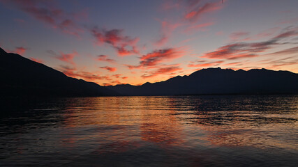 Suggestivo tramonto sul lago in autunno, con nuvole colorate di rosa, rosso e arancione. Immagine molto bella.  © fotonaturali