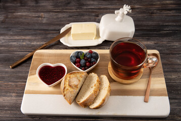 Breakfast with a Cup of tea, bread, butter and jam in a rustic style 
