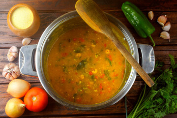 Pirão is a traditional dish of Brazilian cuisine made from cassava flour, fish or shrimp, in a pan on a rustic wooden table.