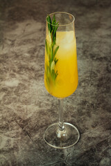 citrus cocktail with ice and rosemary on a dark background.