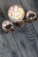 Marshmallow in a jar. With cookies and chocolate. On pine boards.