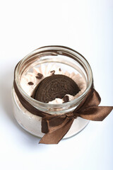 Marshmallow in a jar. With cookies and chocolate. On a white surface.
