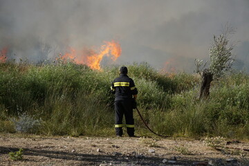 2017. LESBOS, GREECE. The firebrigade in Lesbos is trying to extinguish a fire with the help of...