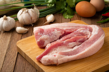 Raw Pork Belly sliced on cutting board.