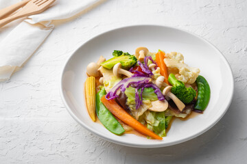 Healthy Vegetarian food, stir-fried vegetables with Shiitake mushroom sauce in white plate (Pad Phak Ruam Mid)