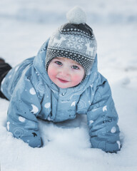 Little boy lies in snow