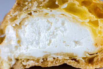 Cupcake with cream on the white plate. Sweet dessert for breakfast. Close up view of cut in half cake inside.