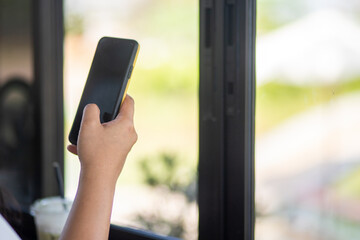 Close up of a woman using a mobile phone in a cafe
