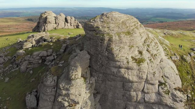 Aerial drone footage of natural granite rock formations of Haytor and green countryside, Dartmoor National Park